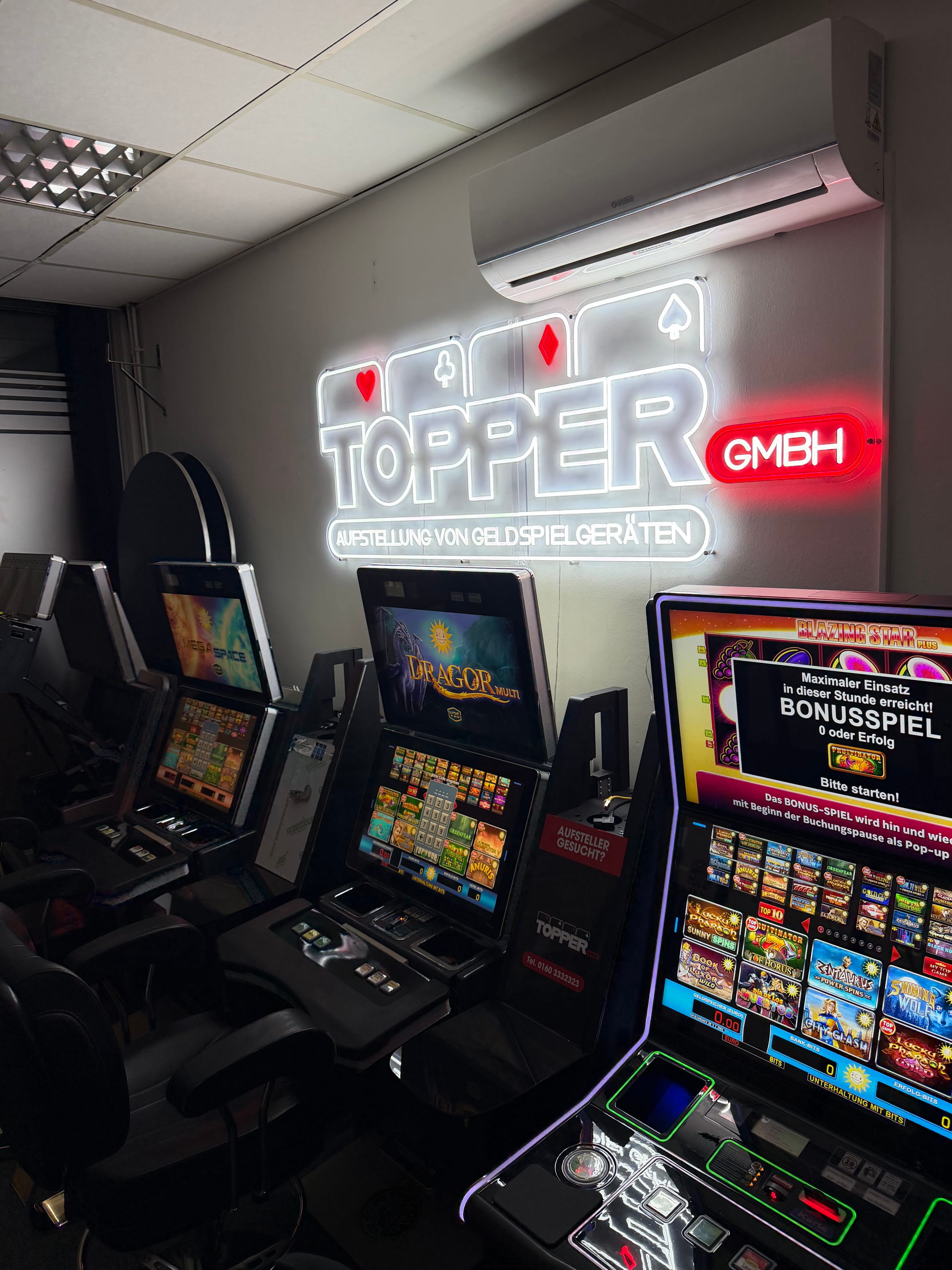 Topper GmbH Neonschild mit mehreren Geldspielautomaten und Blazing Star Plus