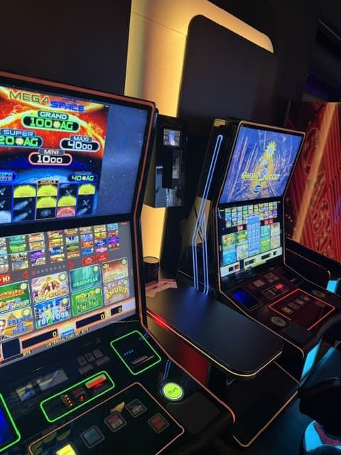 Mega Slots Automat mit grüner LED-Umrandung neben weiterem Spielgerät