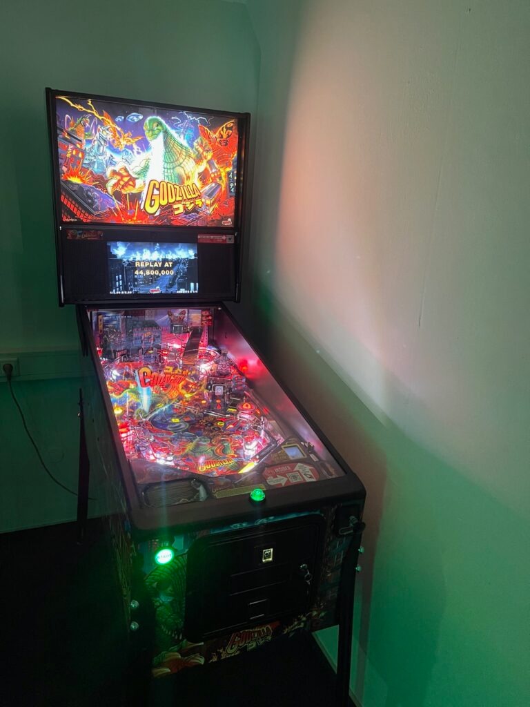 Godzilla-Flipperautomat mit bunter LED-Beleuchtung in grünem Ambiente