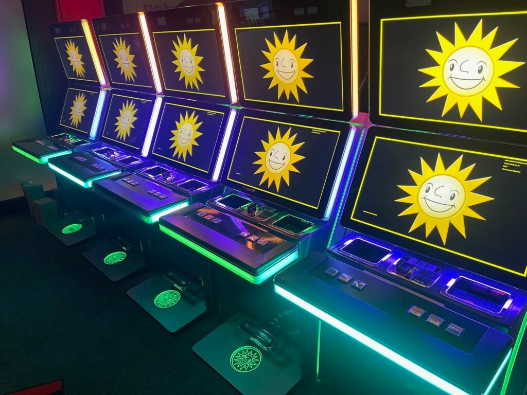 Reihe von Spielautomaten mit Sonnensymbolen und bunter LED-Beleuchtung