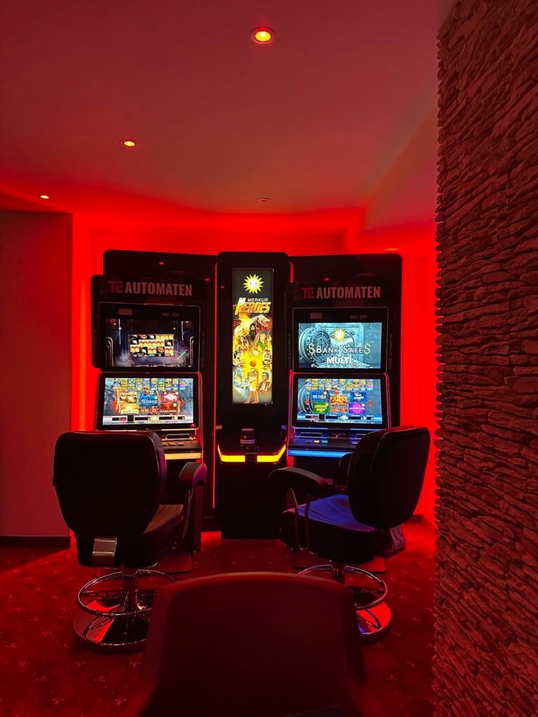 Drei TE AUTOMATEN in dramatischer roter LED-Beleuchtung mit Steinwand