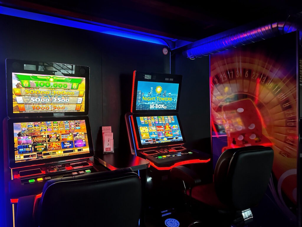 Atmosphärischer Gaming-Raum mit NIGHT TOWERS M-BOX und imposanter Roulette-Wandprojektion