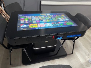 Interaktiver Gaming-Tisch mit Touchscreen-Interface und komfortablen Sitzplätzen